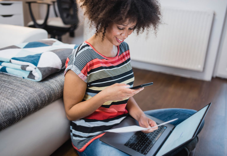 Woman sat on the floor scanning a document.